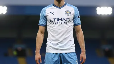 A tight waist-up shot of an anonymous Swansea City player in a white jersey with a blue and white striped shirt, blue...