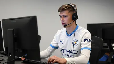A young, anonymous, 25-year-old, male, Swansea City player, wearing a white, long-sleeved, jersey, with a blue...