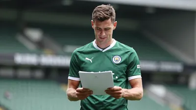 Mid-30s anonymous Swansea City midfielder, athletic build, waist-up in dark green home shirt with white trim, plain...